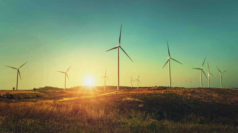Wind turbine on hill with sunset