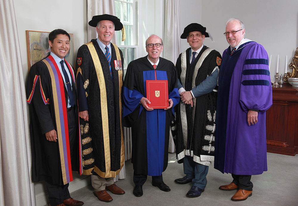 Stephen Smith holds his honorary degree with Queen’s Rector Cam Yung, Chancellor Jim Leech, Principal Daniel Woolf and Dean David Saunders.