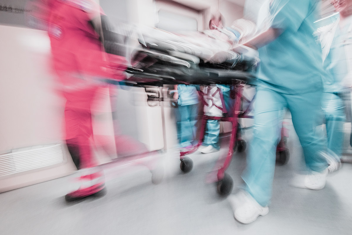 emergency medical staff moving through hallway