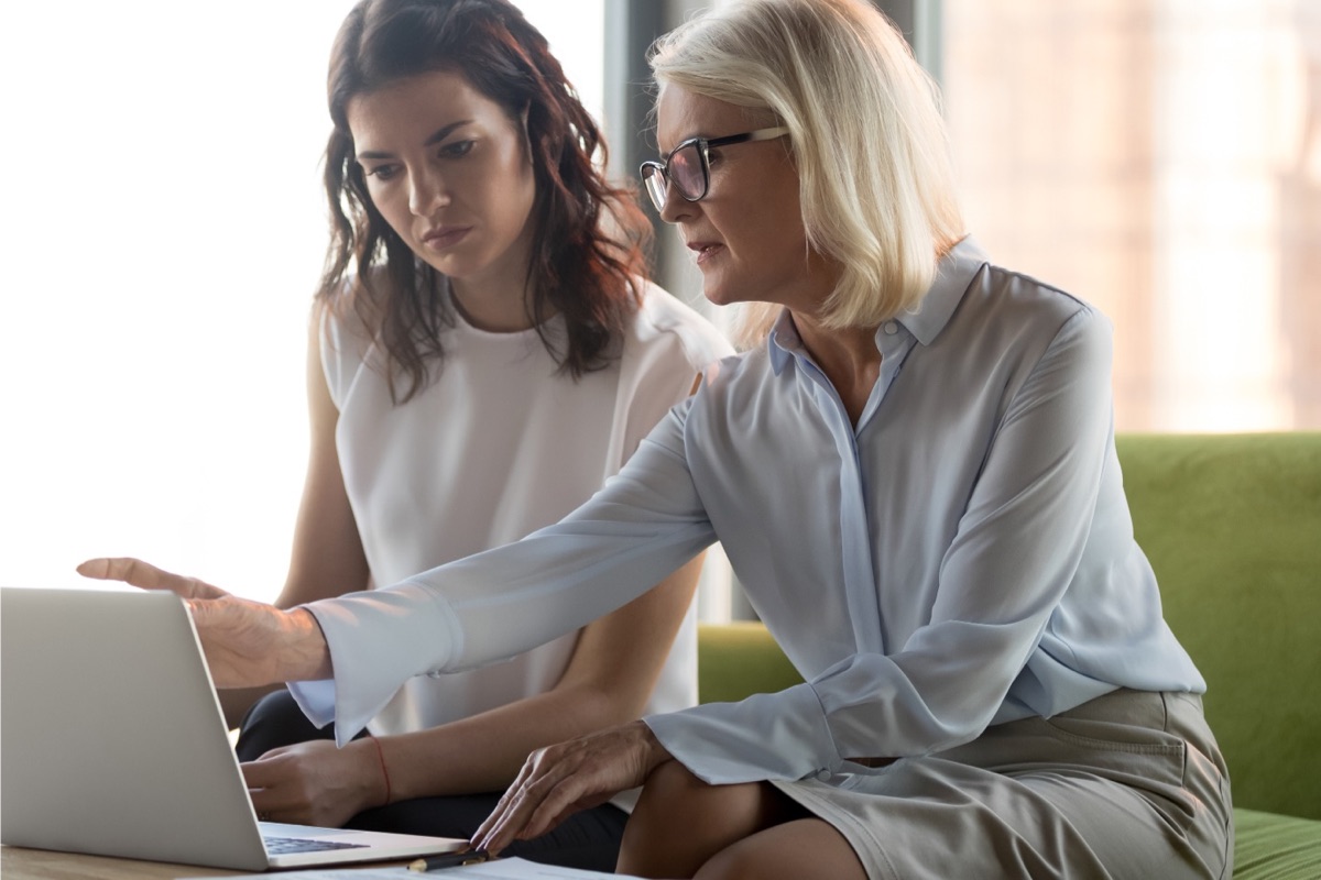 A career coach and a student viewing a laptop screen